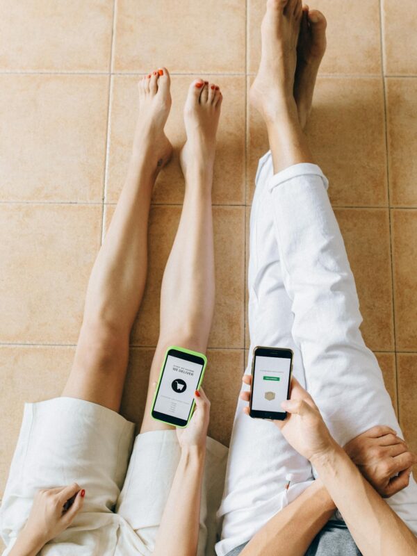 Person in White Pants Sitting on Brown Ceramic Floor Tiles